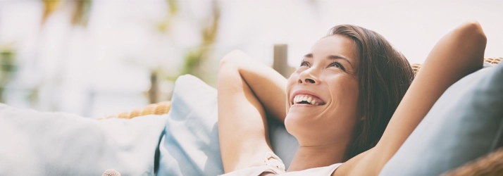 a woman resting in teh couch, smiling and very relax.